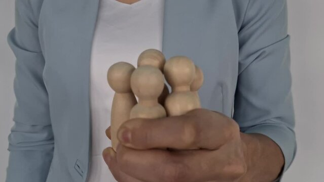 Group team of wooden figures in boss fist. Controlling people at work and in society