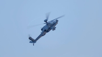 British army Boeing Apache Attack helicopter gunship (AH64E AH-64E ArmyAir606) banking hard in...