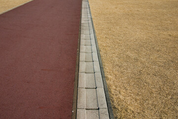 冬の公園の地面と芝生を分ける雨水の側溝