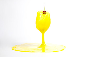 Glass with yellow foamy cocktail on white background, foam in glass