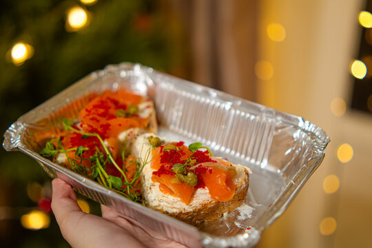 bruschetta with salmon in an aluminum container from food delivery.delivery of delicious food to your home.