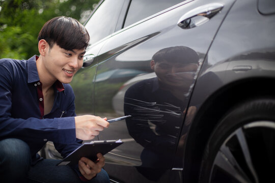Claim inspector examines outdoor road accident car with form And show friendly and bright smiles throughout the service to customers.
