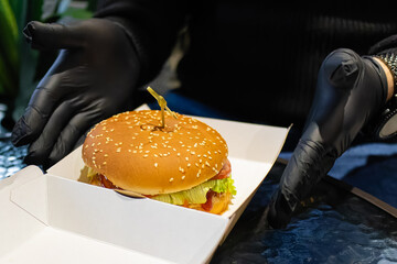 Holding a hamburger in his hands. Delicious appetizing burger.Fast food cafe.American food.Burger...