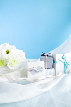 ブルー背景の花束とプレゼントの素材　ホワイトデーやウエディングのイメージ