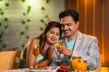 joyful romantic Indian couples spending time together during candlelight dinner at restaurant - concept of relationship closeness and date night affection