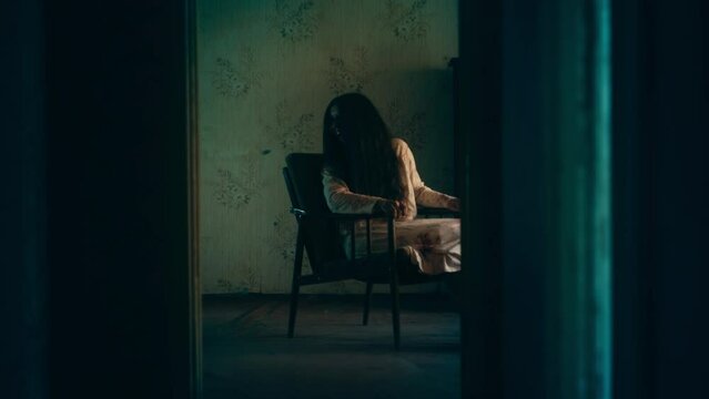 Looped sequence of scary old woman sitting in armchair and laughing, paranormal