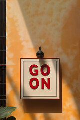go on sign in front of yellow wall with copy space