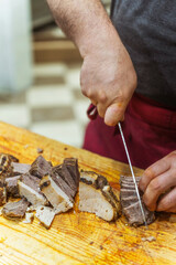Slicing beef meat for Kazakh beshparmak. Preparation of horse meat by the chef's hands for hot dishes. Cutting large pieces of meat into small slices