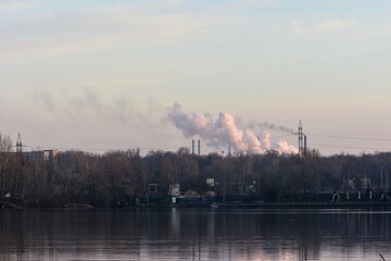 metallurgical plant releases smoke into the atmosphere over the lake