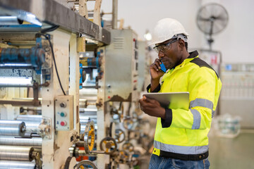 Side view, African male engineer It is next to the working machinery of the plastic and steel...