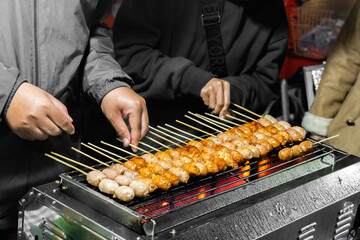 Northeastern Sausage,Thai street food. Thai sausage grilled on stall. Sai Krok Isaan or Pork sausage with rice grill. Made of pork and spiced with garlic and white peppercorns. Isaan sausage. - obrazy, fototapety, plakaty