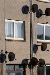 Satellite dish in group on wall of council house
