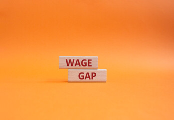 Wage Gap symbol. Concept words Wage Gap on wooden blocks. Beautiful orange background. Business and...