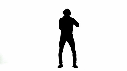 Silhouette of a male activist isolated on a white alpha channel. A Protestant man holds a megaphone near his mouth.