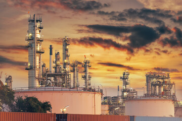 Oil refinery with a train car in the foreground and a beautiful sky in the background.