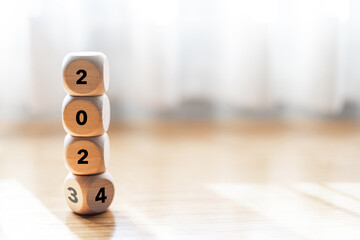 2023 turning to New Year 2024 on wooden block on wood table. Planning and goal concept. Start to...