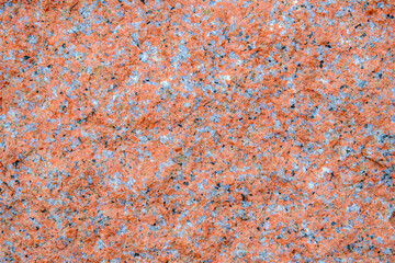 Closeup of natural and rough red granite. The granite fills the frame.