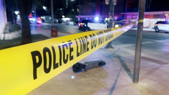 Police yellow tape on the street at night. Transport accident on the road in dark time. Police cars with flashing lights parked on street road. Yellow stripe with text Police line do not cross