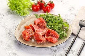Sliced salmon with fresh arugula