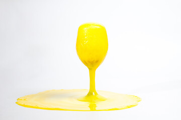 A glass with a yellow foamy cocktail on a white background, foam in a glass