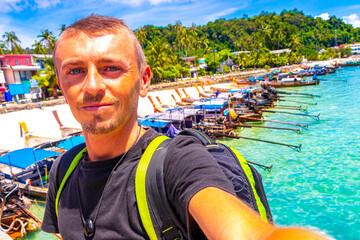 Tourist on Koh Phi Phi island Thailand with longtail boats.