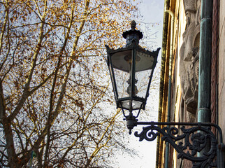 historic lantern in Dusseldorf oldtown with trees in the background