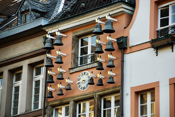 Panoramic photo of an historic facade with a clock and bells