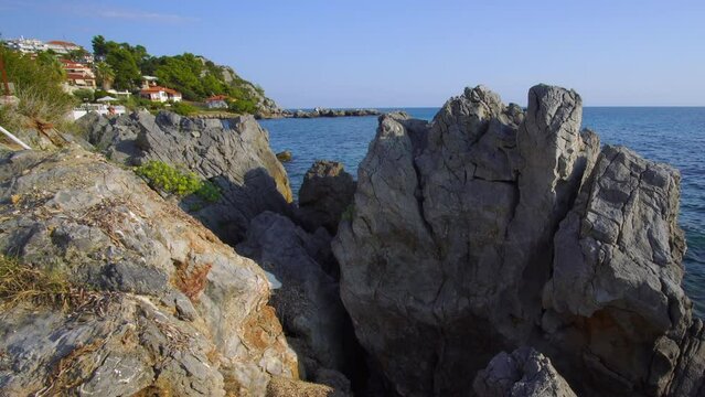 Beautiful view of the Aegean Sea through the rocky shore of the old Greek village of Loutra at sunset