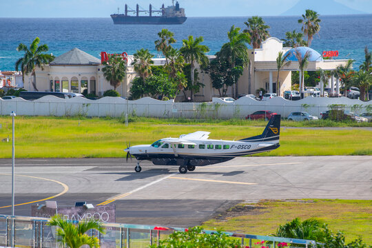 St. Barth Commuter Cessna 208B Grand Caravan takeoff on Princess Juliana International Airport SXM near Maho Beach on Sint Maarten, Dutch Caribbean. 