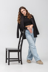 Fototapeta premium girl model in black shirt and blue trousers posing relaxed in studio