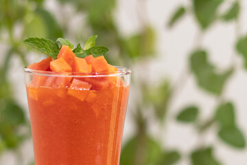 Papaya Juice Smoothies in Glass Cups on White Table: Tropical Fruit Delight with Dazzling Bokeh Background – Perfect for Vibrant and Refreshing Summer Design Concepts