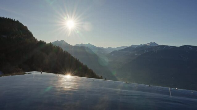 An infinity pool merges seamlessly with the winter mountain terrain, creating a breathtaking of warmth and cold. The crystal-clear waters reflect the snowy landscape. High quality 4k footage