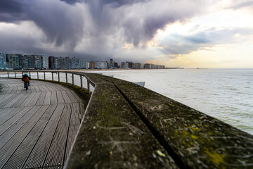 The pier of Blankenberge with the sea and different weather conditions.  Belgium coast toerism.  Belgium coast, north sea.  Kid riding bicycle, bike, toerism belgium.