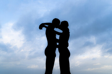 A silhouette of a couple kissing with blue sky.  Silhoutte of romatic couple at the belgium coast city Knokke or Knokke-Heist.  Love at the coast.  North sea lovers.  Sky romance kissing.  Abstract 