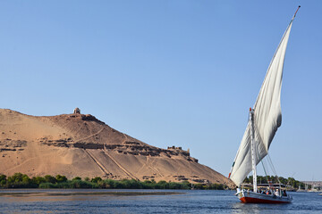 Feluke auf dem Nil am Berg Qubbet el-Hawa bei Assuan, Ägypten
