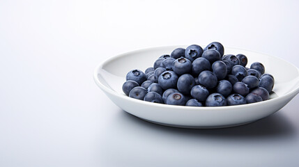 Fresh blueberries in a white plate on a white background. Healthy diet.