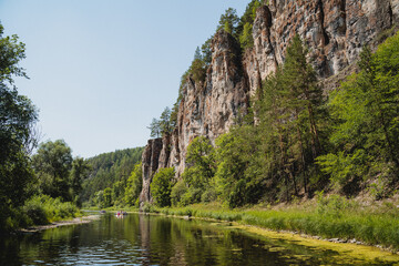 Beautiful summer landscape in sunny weather, mountain river with steep rocky banks, green forest.