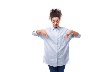young fashion woman caucasian woman with curly black hair gathered in a ponytail wears a blue shirt