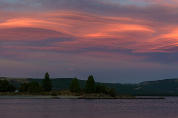 Atardecer en paisaje montañoso de lago con nubes coloreadas