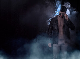 Photo of a shirtless man, with muscular body under leather jacket