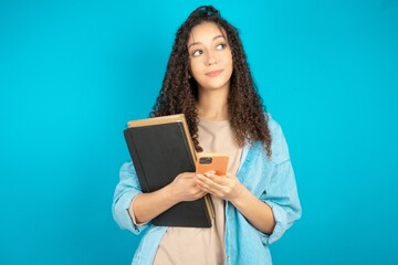 beautiful teen girl wearing denim jacket holds telephone hands reads good youth news look empty space advert