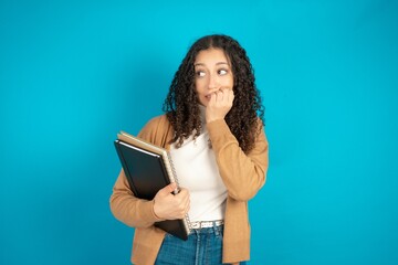 Terrified beautiful teen woman wearing beige knitted jacket looks empty space home alone moonless night