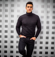Photo of a young and handsome man with his hands casually in his pockets, standing confidently in...