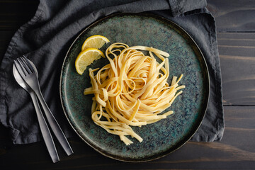 Fettuccine with Lemon-Mascarpone Sauce: A plate of wide noodles served garnished with lemon wedges