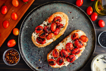 Mascarpone Toast with Burst Tomatoes: Slices of crusty bread topped with creamy cheese, charred grape tomatoes, and extra virgin olive oil