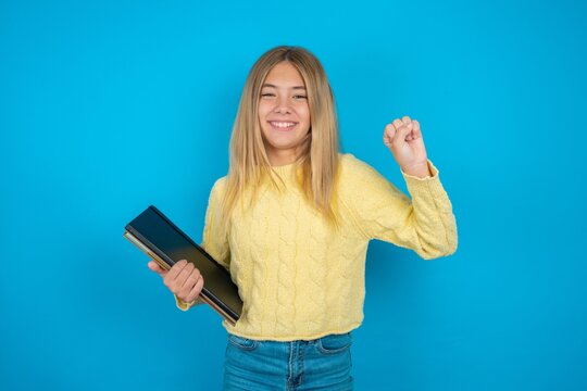 Beautiful Kid Girl Wearing Yellow Sweater Holding Notebook Pointing Up With Fingers Number Ten In Chinese Sign Language Shi