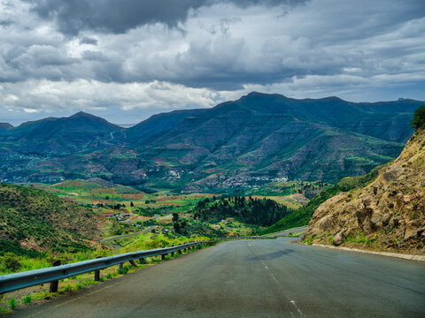 Winding road through Lesotho villages, valleys and mountain during a couldy summer day