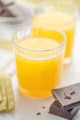 Orange juice in a fluted glass with dark chocolate pieces and chocolate chips.