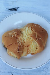 Banana cheese torn bread with cheese sprinkled in a plate on the table
