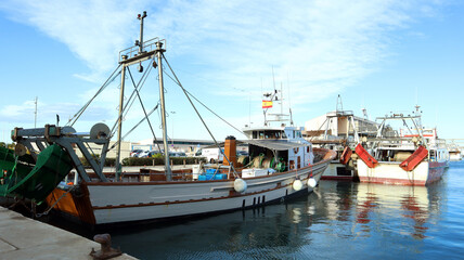A small fishing ship in the seaport of Spain, view from the stern 